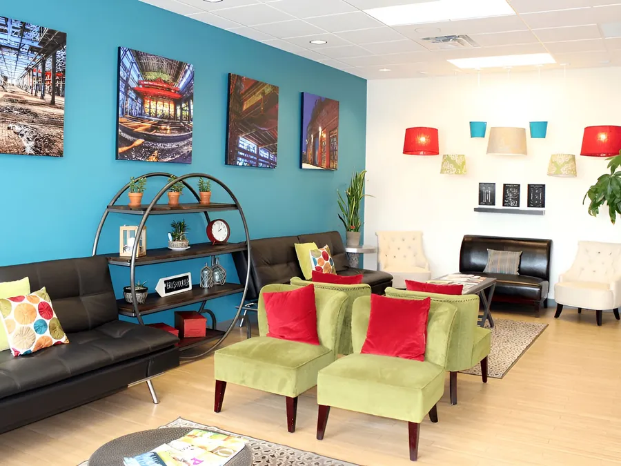 Comfortable waiting lounge with green armchairs, sofas, and local Albuquerque artwork