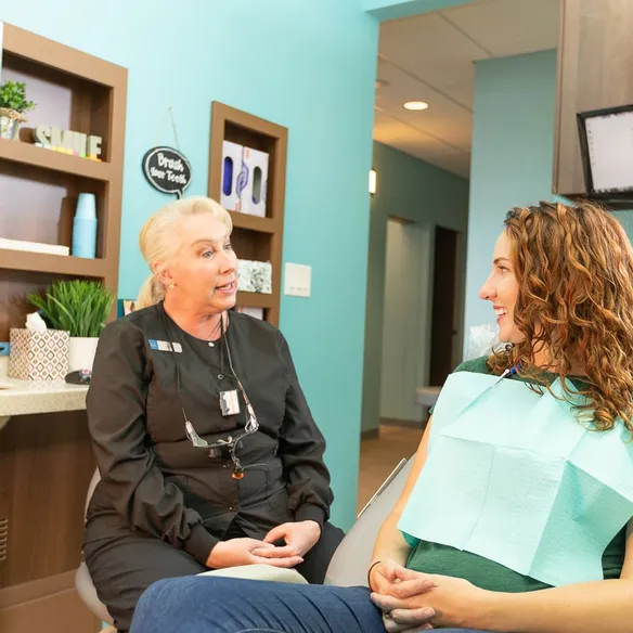 Desert Ridge Dental hygienist talking with a patient in a treatment room
