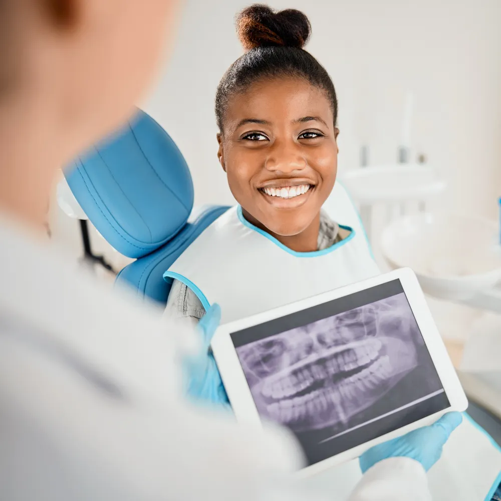Dentist reviewing a dental X-ray with a patient during a surgical consultation