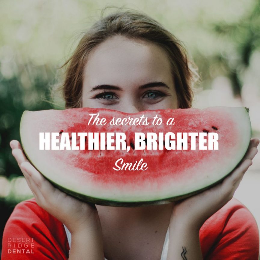 Woman holding a quarter watermelon in front of her face like a smile.