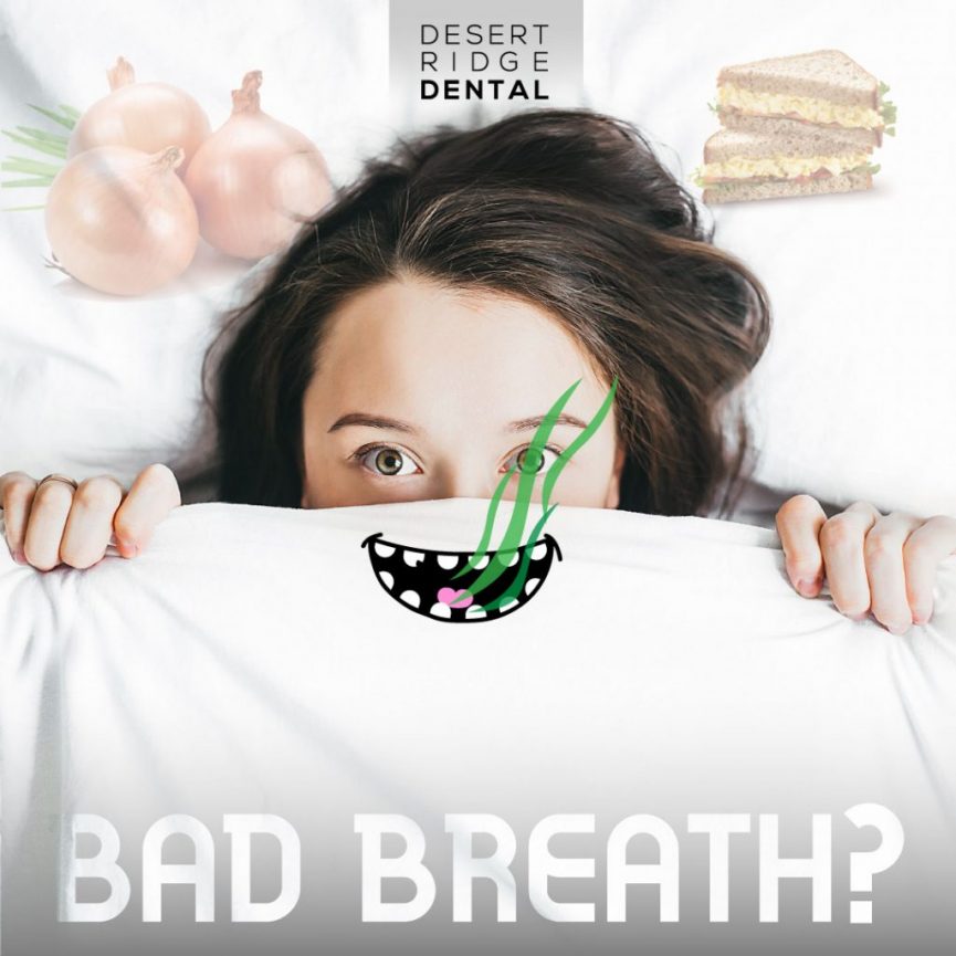 Woman holding a t-shirt with a mouth with bad breath on it over her own mouth.
