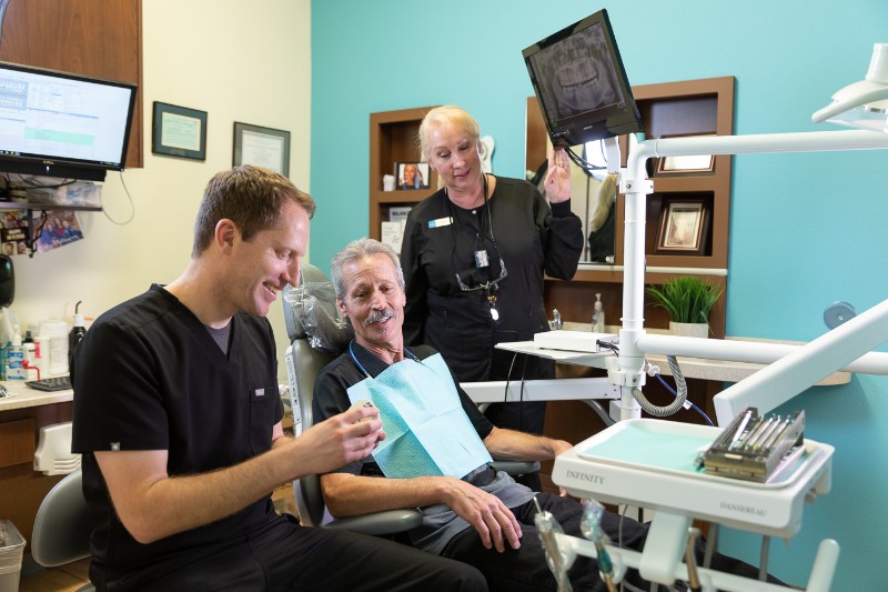 Dr. Mink and hygienist speaking with dental patient.