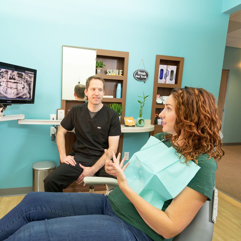 Dr. Mink speaking with female dental patient.